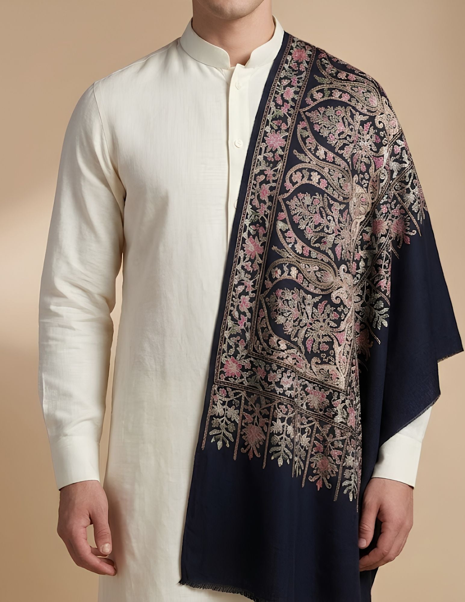 Close-up of Aari chain-stitch embroidery in gold and dusty pink on midnight blue.