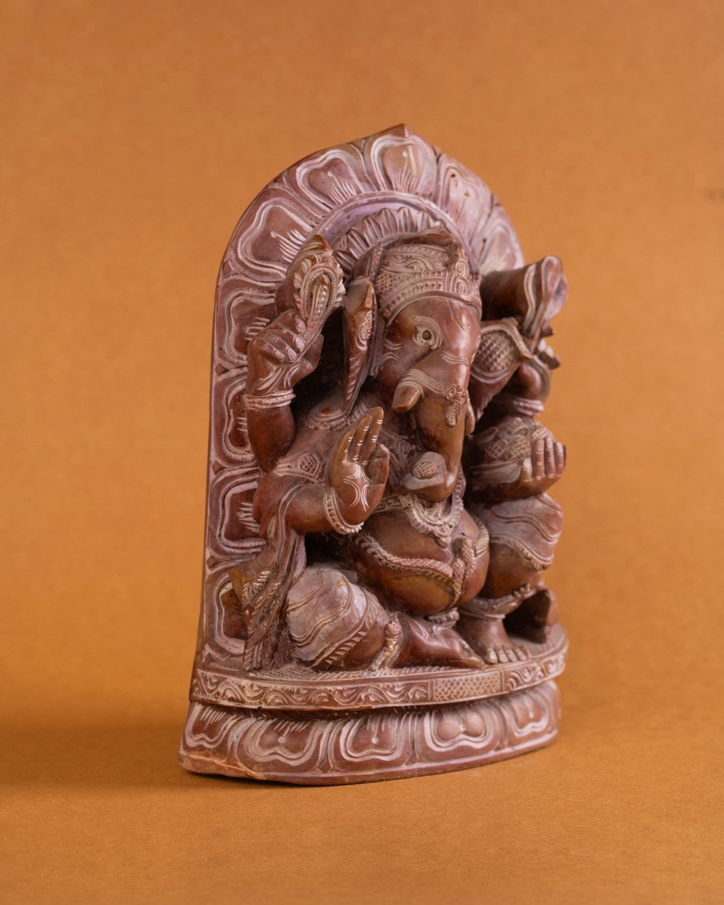 Red stone Ganesha statue in prayer position for home altar décor
