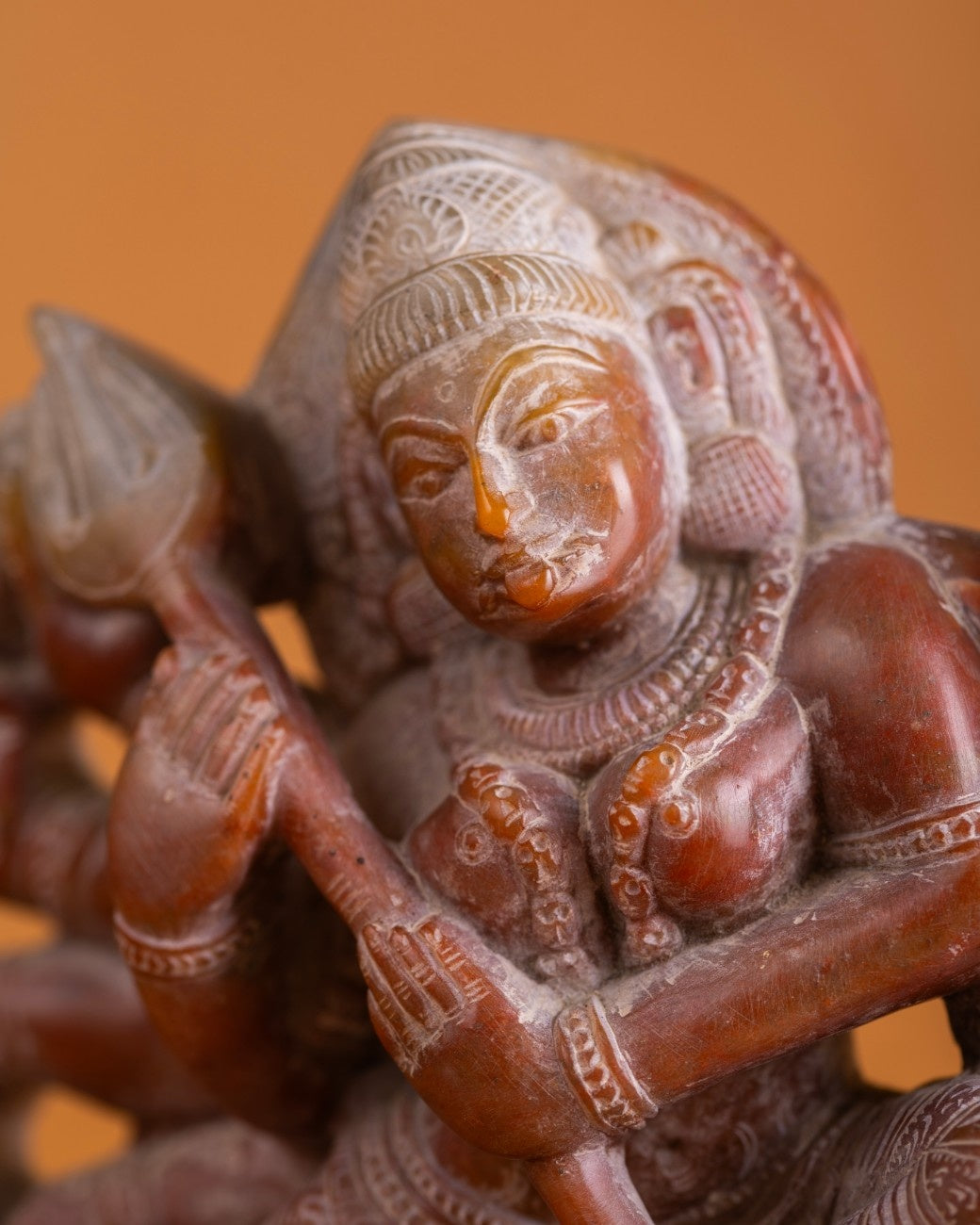 Close-up of red stone Kali statue – detailed Indian stone sculpture