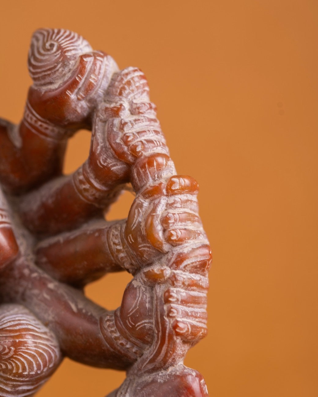 Intricately patterned stone-carved feet from a traditional figurative sculpture - Kali statue in Red Stone