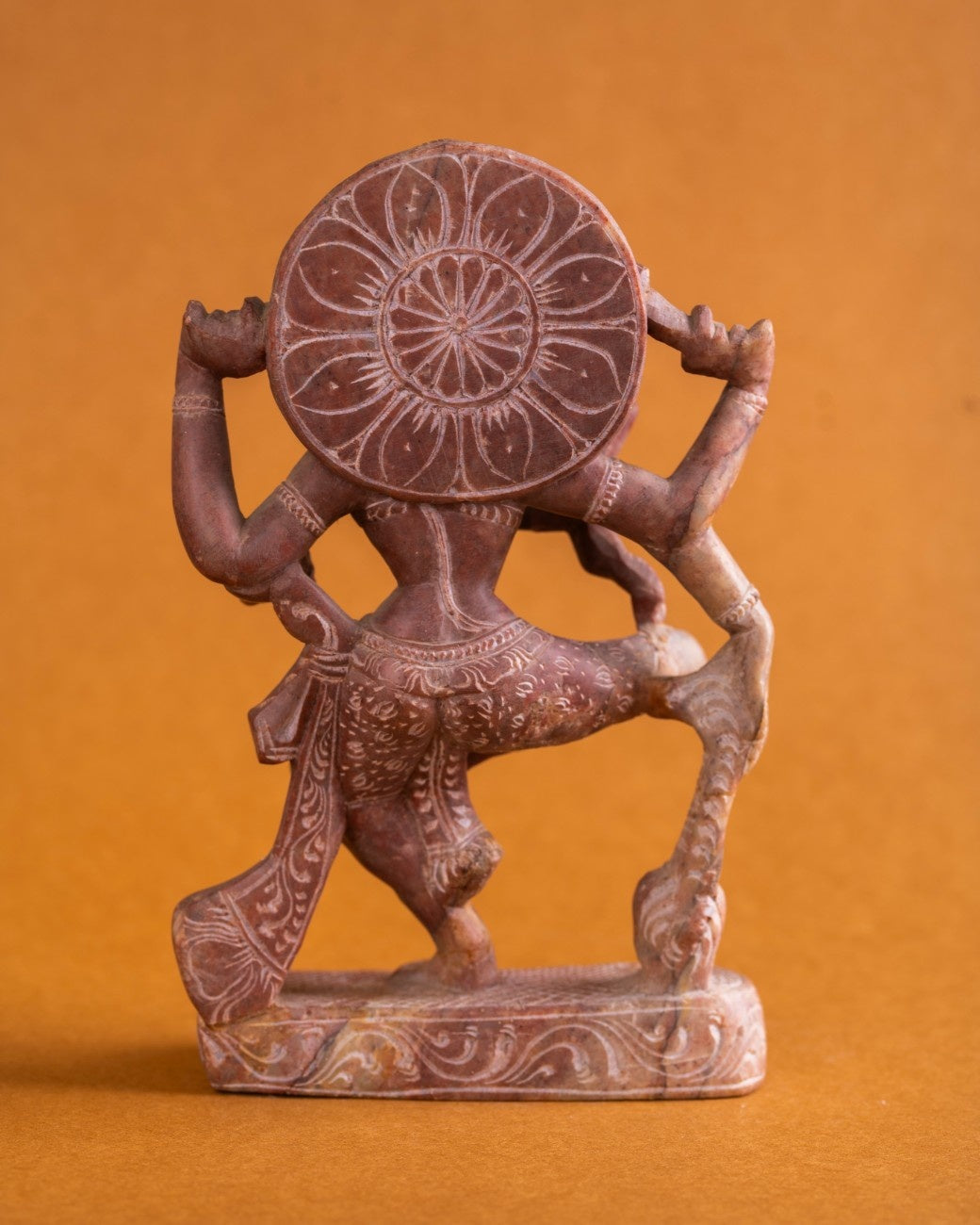 Rear view of handcrafted red sandstone Shiva statue showing carved details.