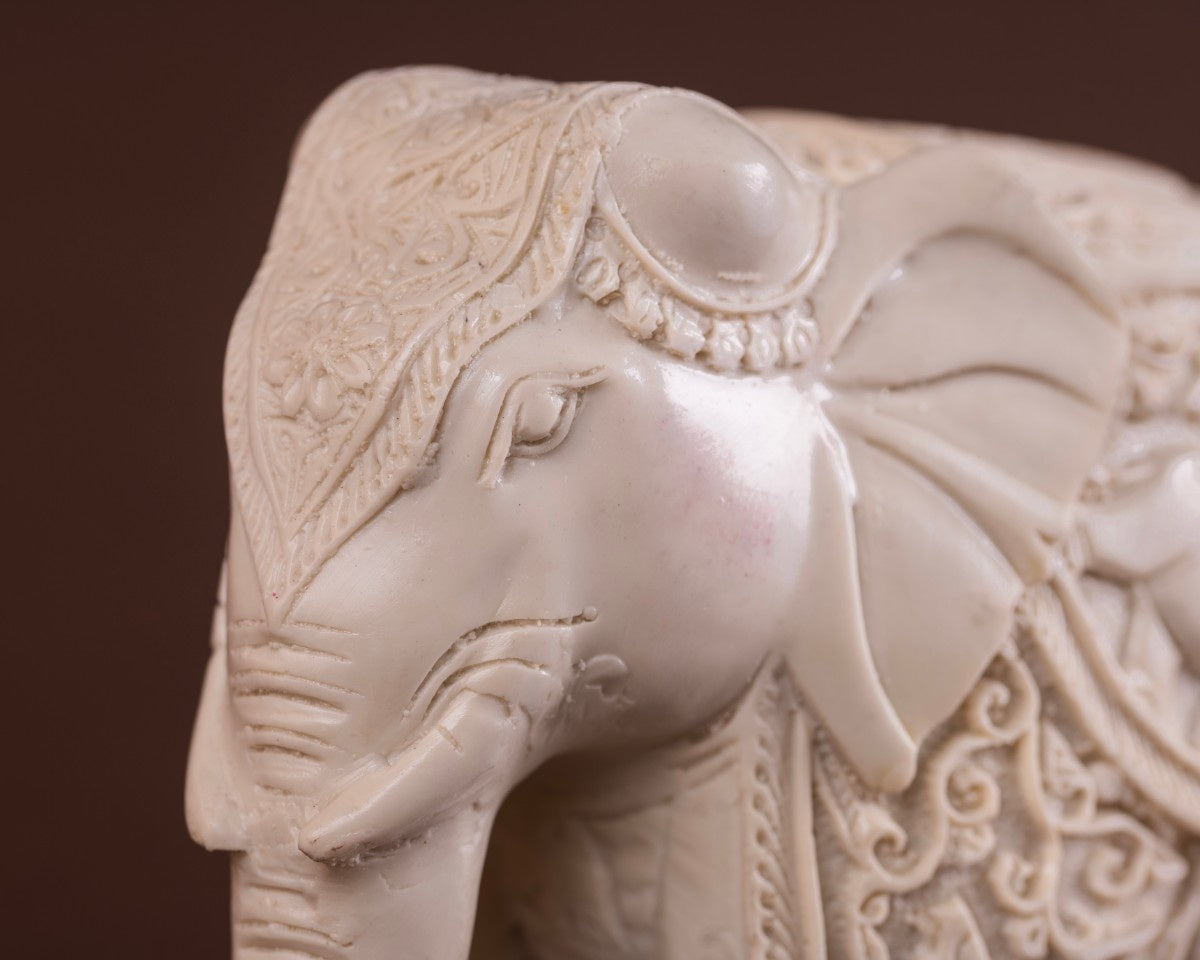 Indian décor white carved elephant figurine close-up with etched detailing and textured craftsmanship.