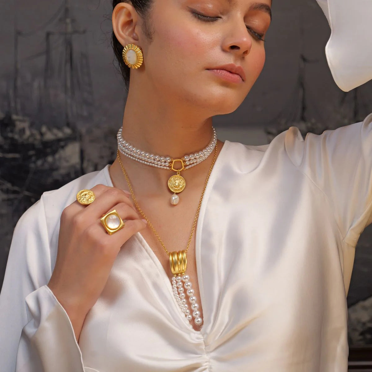 side view of woman wearing pearl choker with gold coin pendant