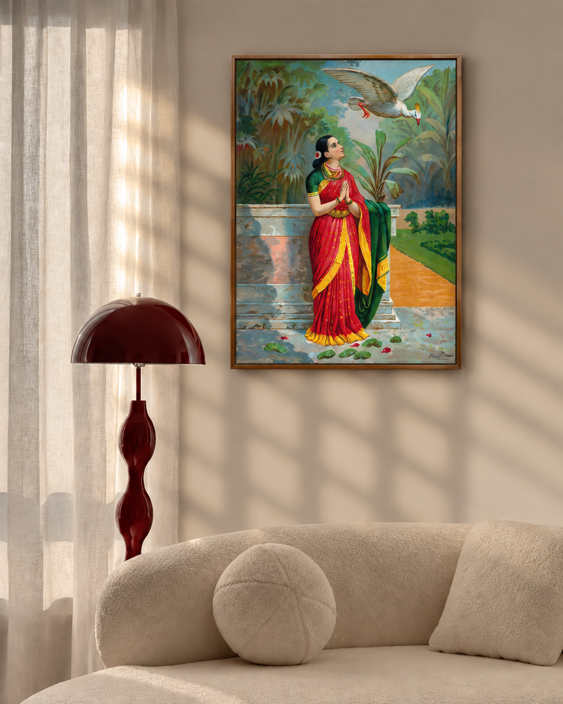 Framed print on a beige wall above a curved boucle sofa beside a dark red floor lamp