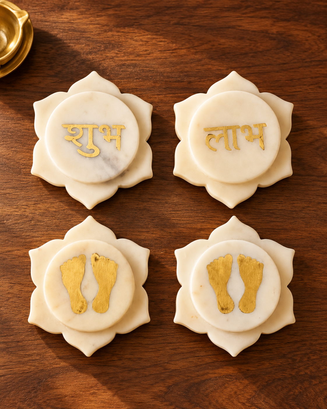 Set of four lotus-shaped white marble décor pieces with brass inlay: Shubh, Labh and two pairs of Lakshmi charan footprints