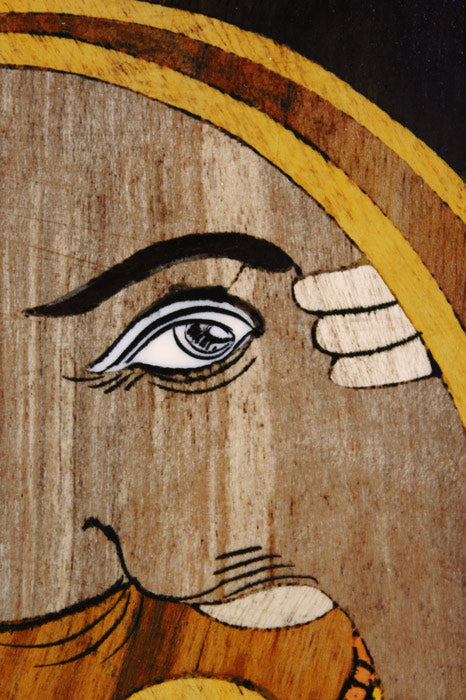 Close-up of intricate Mysore rosewood inlay detailing on a Ganesha wall panel, highlighting fine hand-cut wood inlay, flowing contours, layered textures, and traditional craftsmanship.