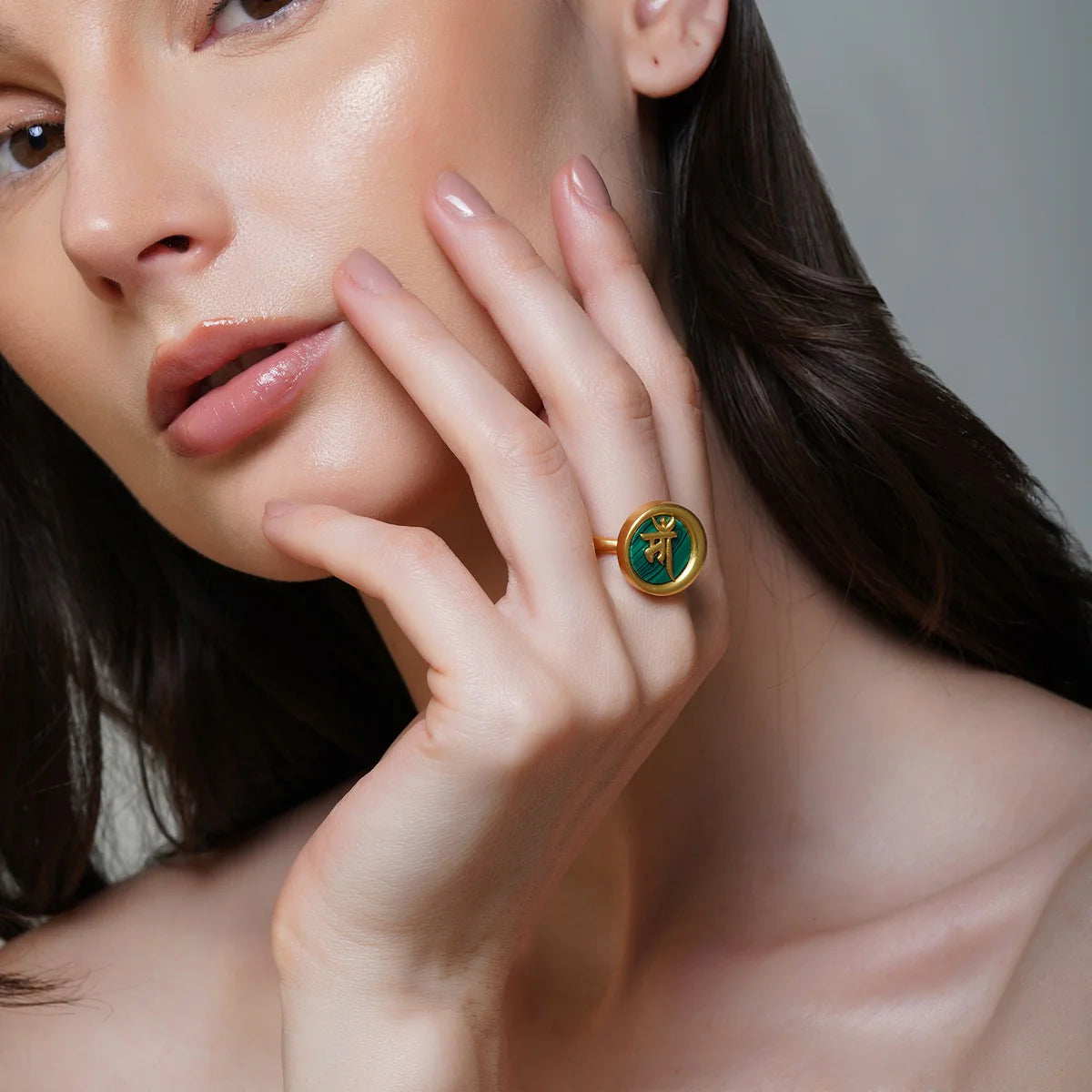 Model wearing gold Ma ring with round malachite center