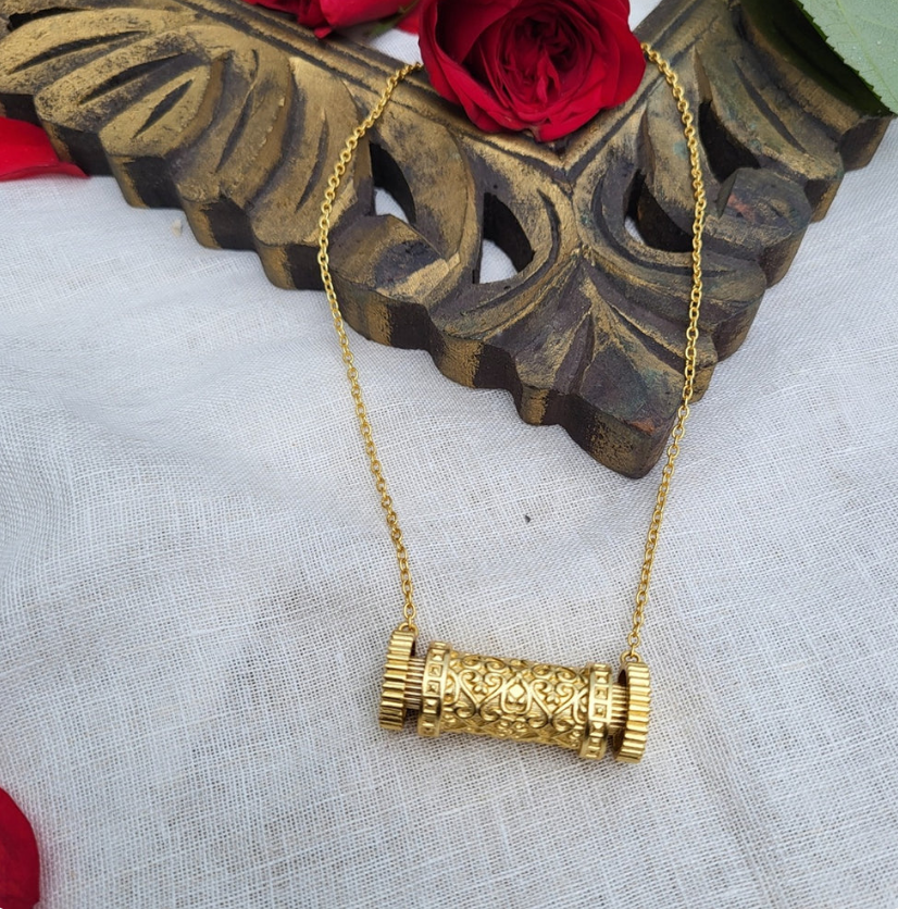 gold-finish cylindrical scroll pendant necklace on traditional fabric, antique-inspired jewelry for women, occasion wear accessory