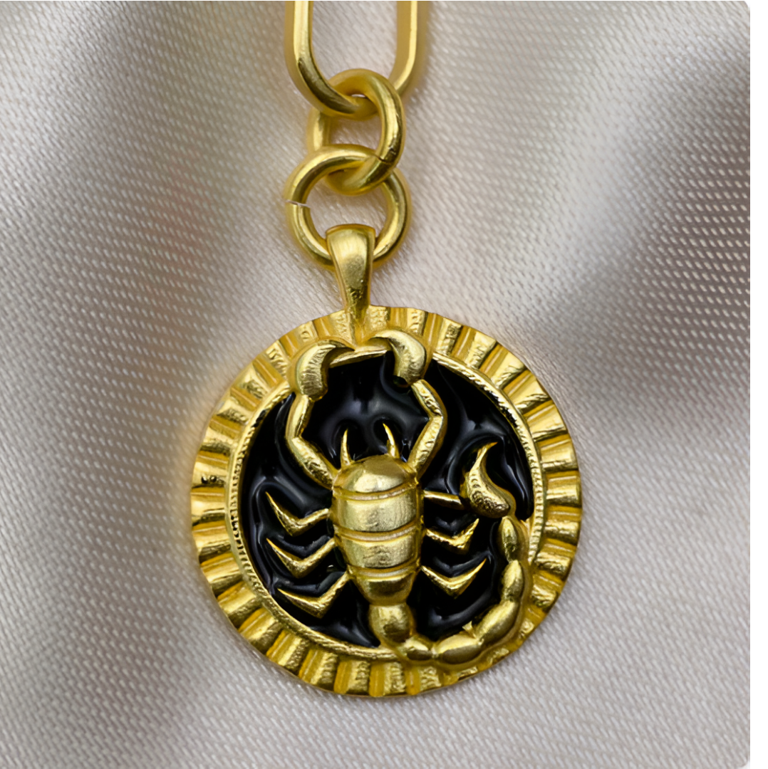 Close-up of gold Scorpio pendant with engraved scorpion on black enamel