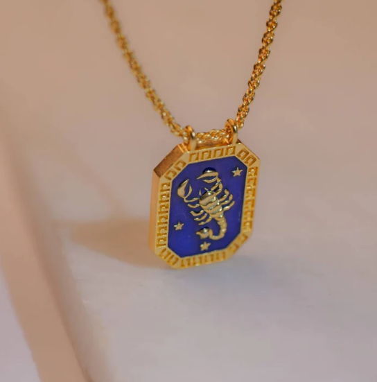 Model wearing gold Scorpio zodiac tablet necklace with enamel pendant