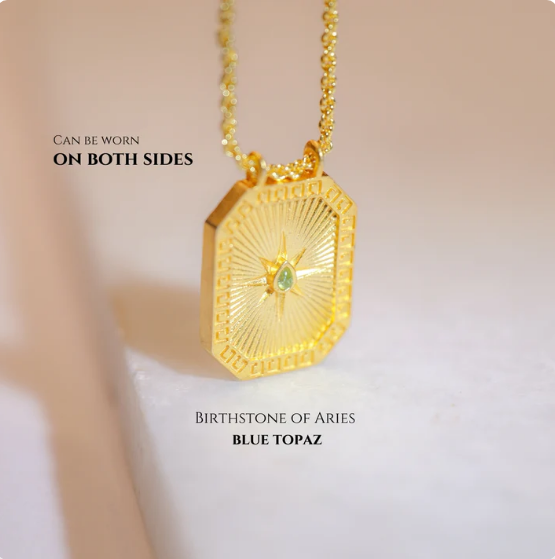 Reversible gold Sagittarius pendant featuring blue topaz back on chain