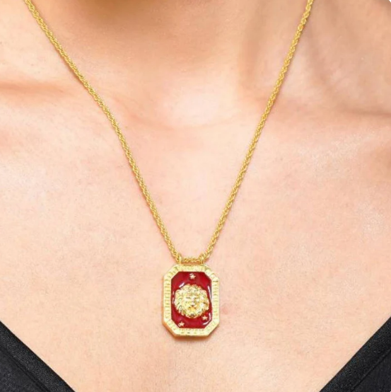 Model wearing gold Leo zodiac tablet necklace with red enamel pendant