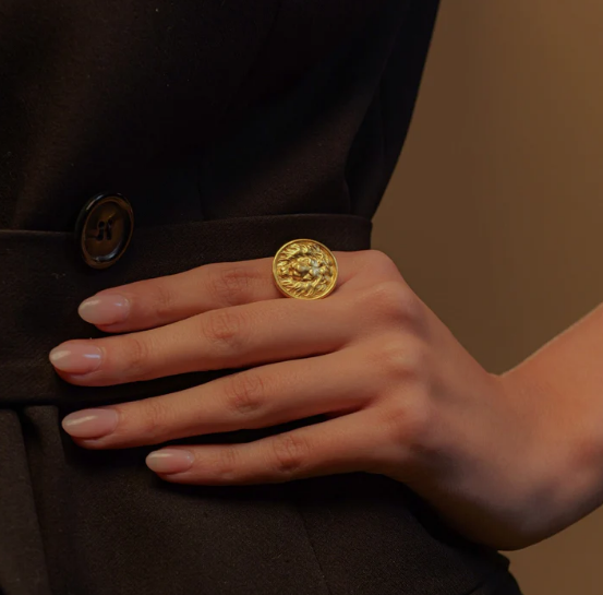 Model wearing gold lion medallion ring styled with neutral outfit