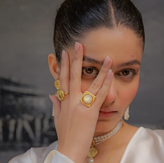 Model wearing gold rectangular mother-of-pearl statement ring
