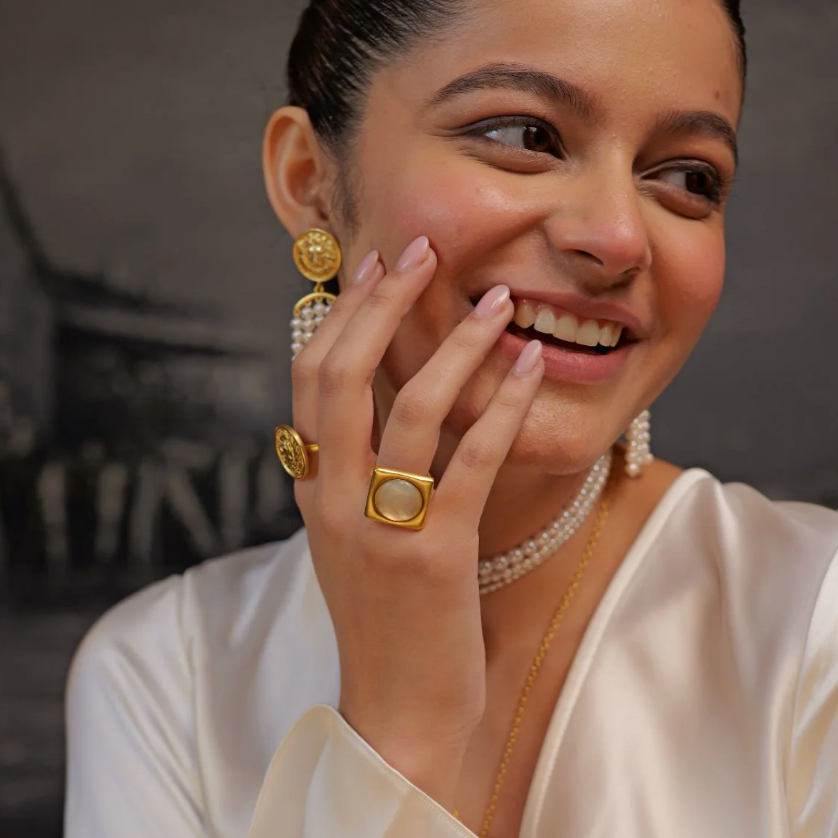Model wearing gold rectangular mother-of-pearl statement ring