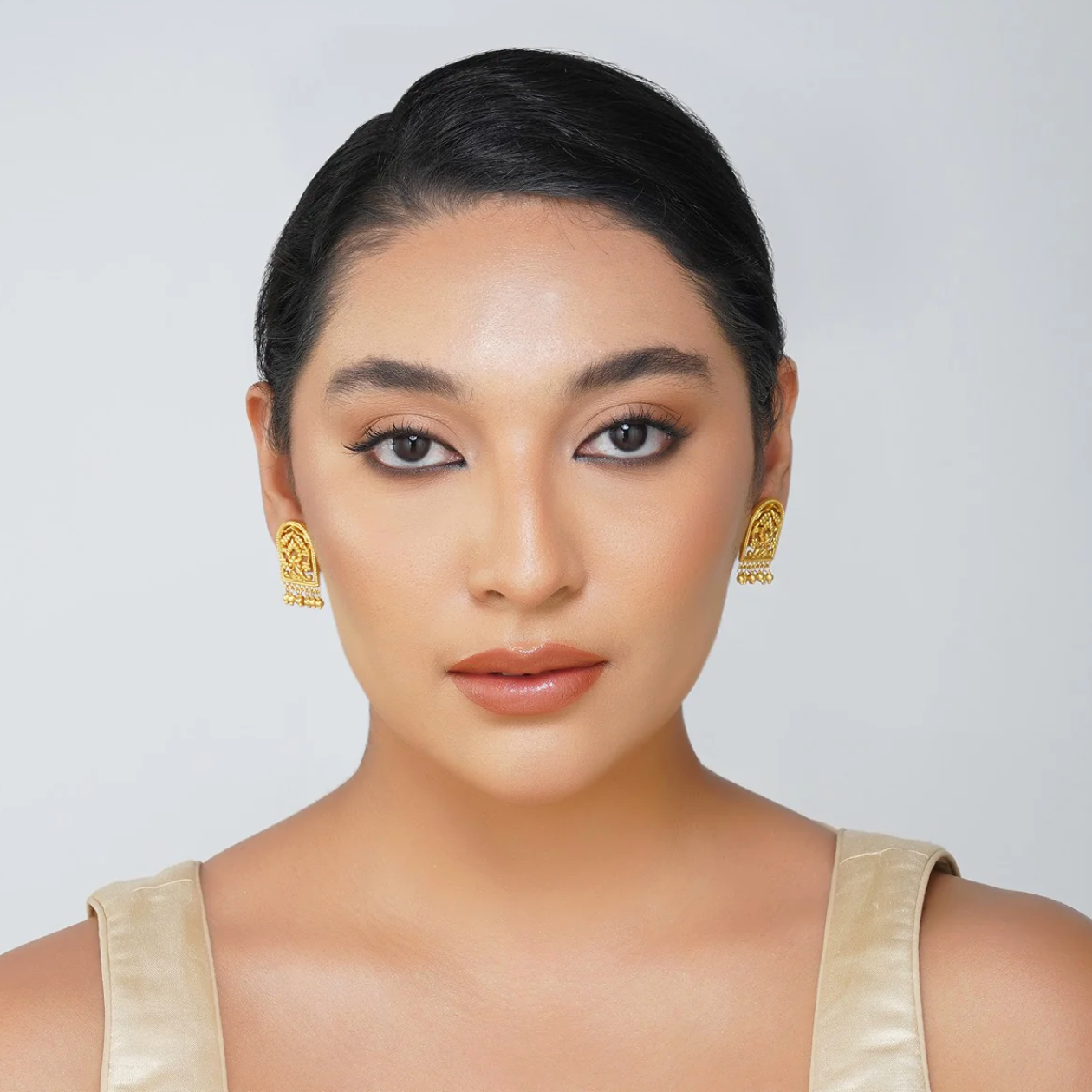 gold-plated filigree stud earrings featuring rectangular floral cutwork and dangling beads worn as statement jewelry for women