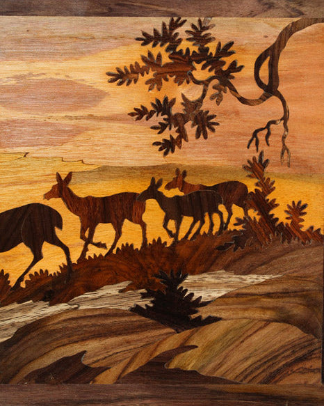 Close-up of Mysore rosewood inlay artwork showing detailed deer silhouettes, trees, and layered wood textures created through precision hand-inlay and carving techniques.
