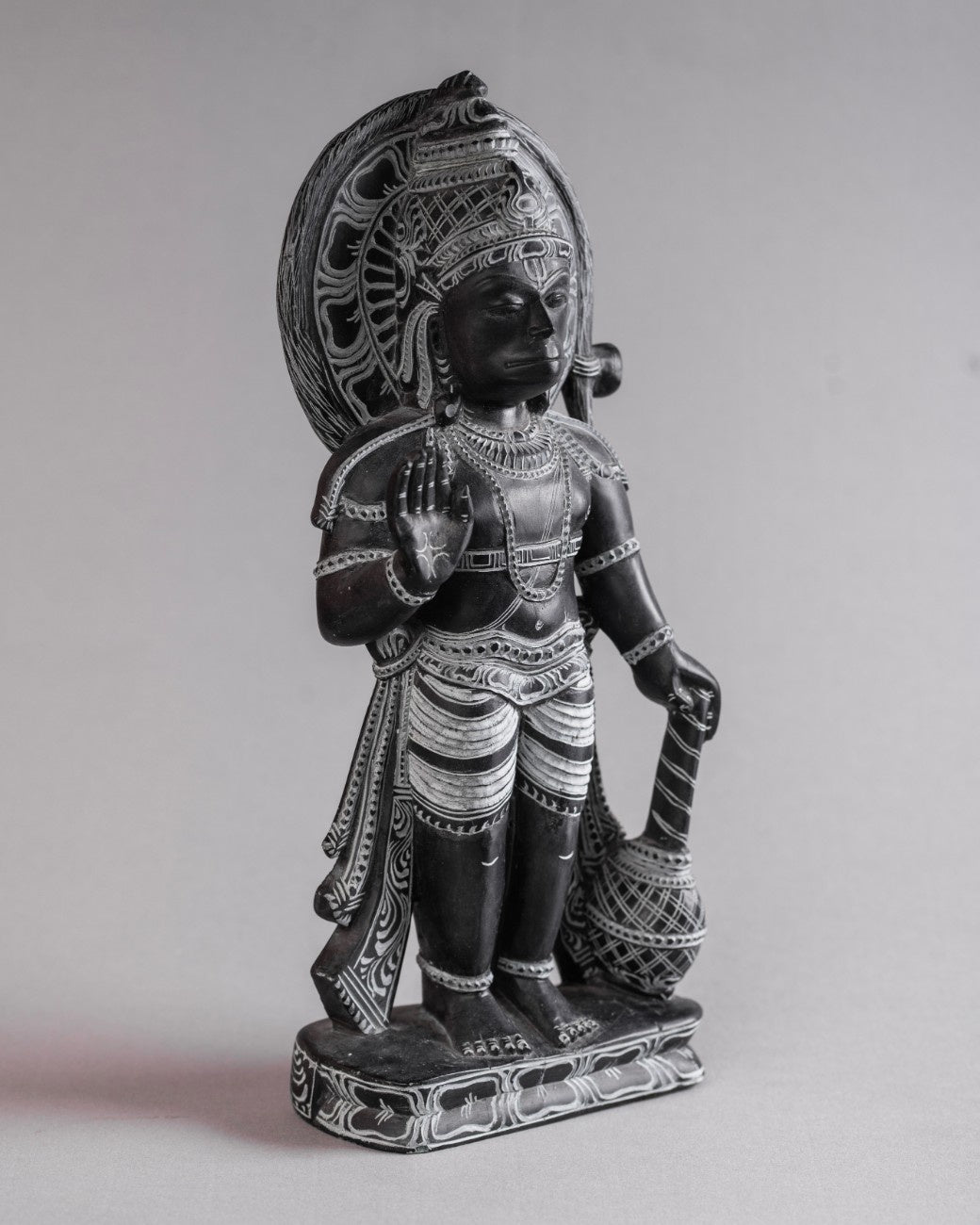 Carved black stone Hanuman statue highlighting textured finish and traditional iconography.