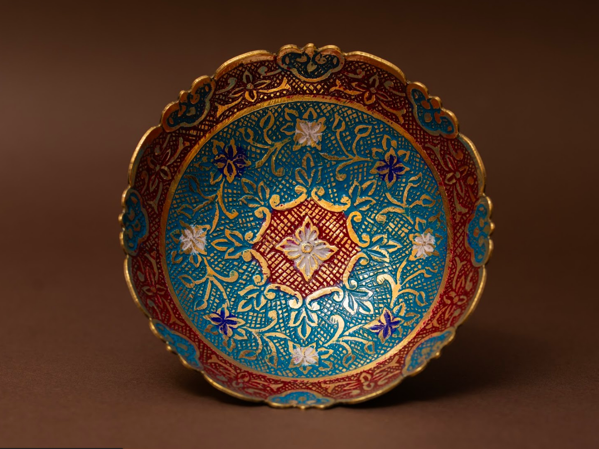 Decorative brass fruit bowl with red enamel work and traditional motifs