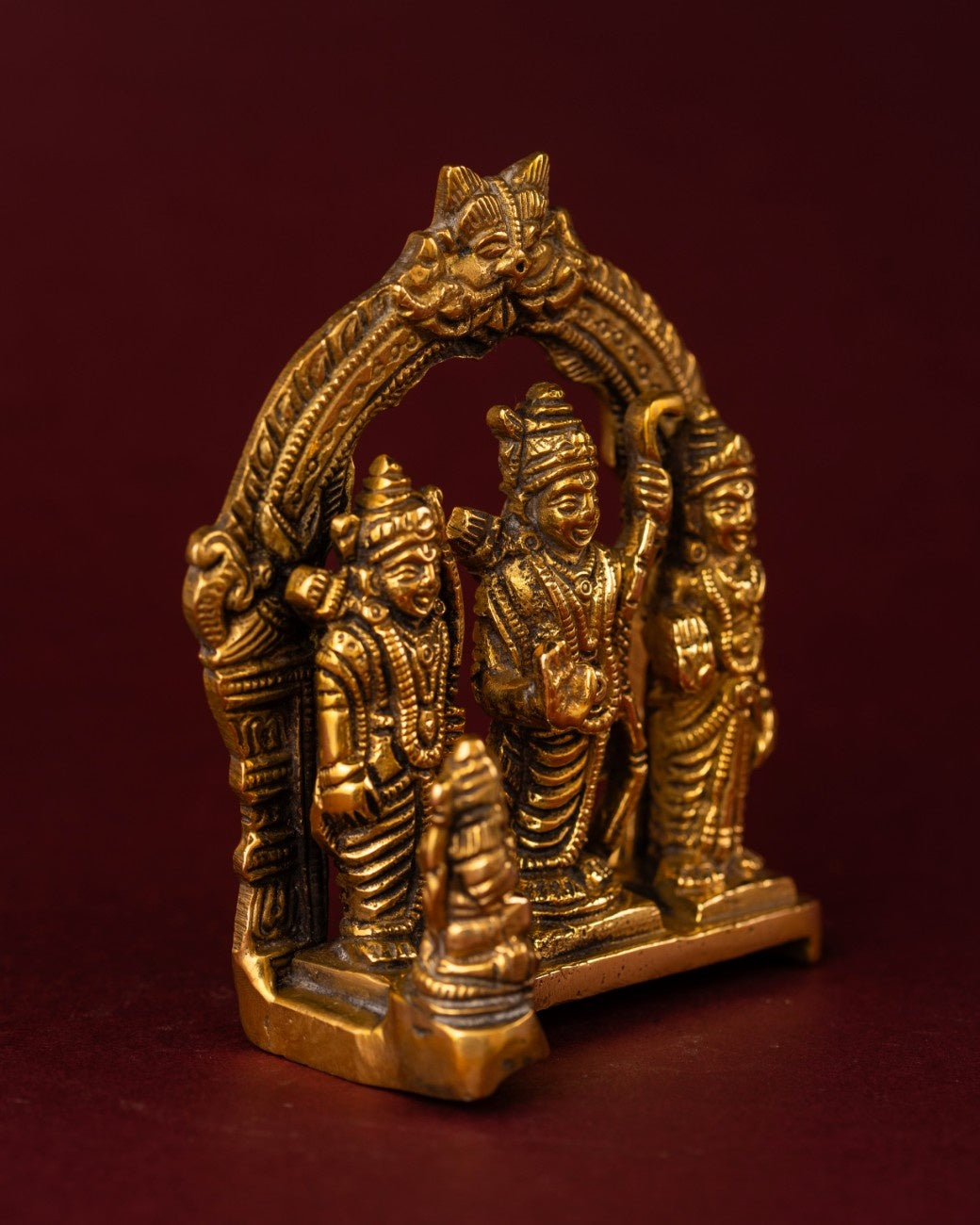 Side-angle view of brass Ram Darbar idol with intricate arch and deity figures, handcrafted Hindu home altar décor