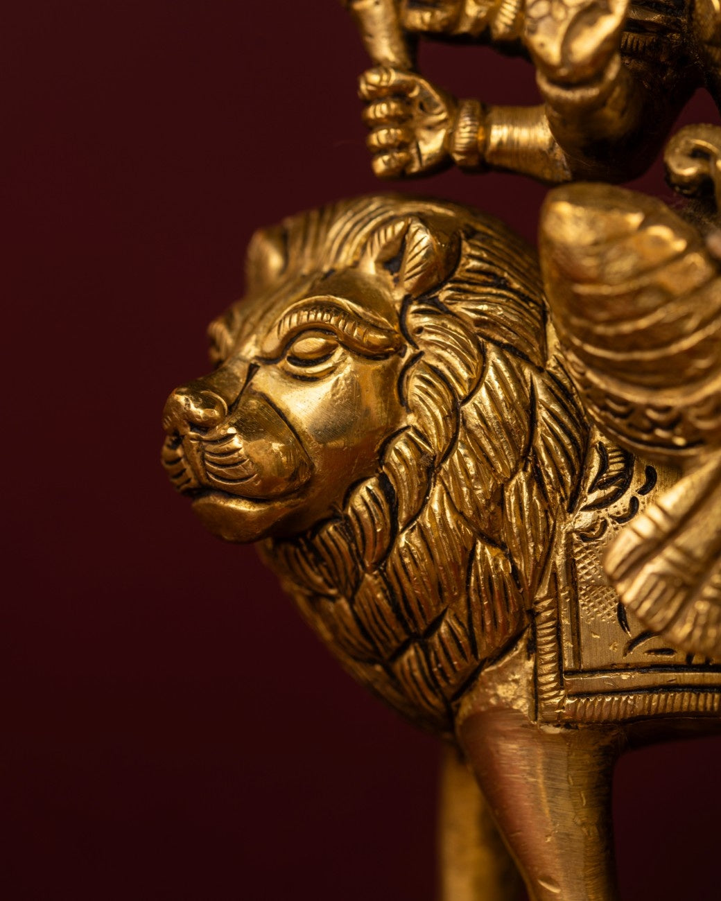 Close-up of the lion base of Indian brass statue of Goddess Durga – detailed brass sculpture.