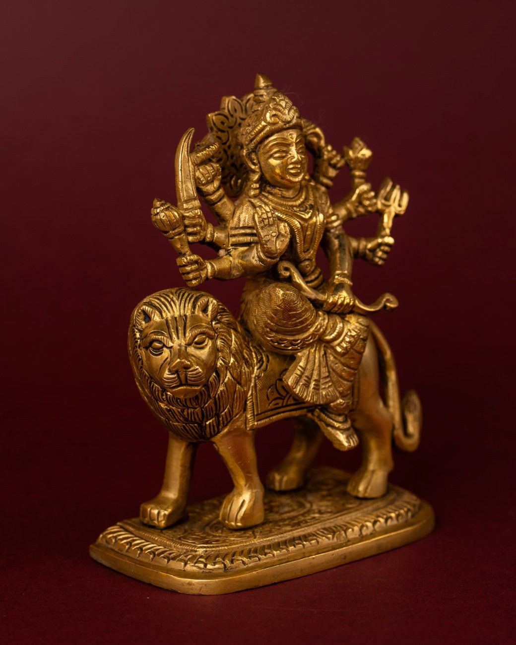 Side view of Indian brass statue of Durga on lion – intricate brass sculpture