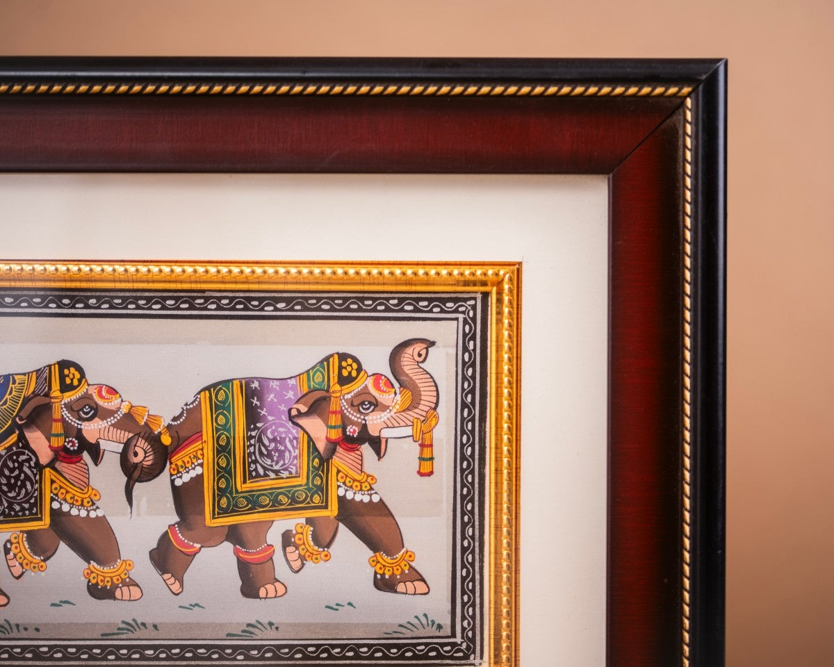 Corner view of framed elephant procession artwork showing border and presentation details