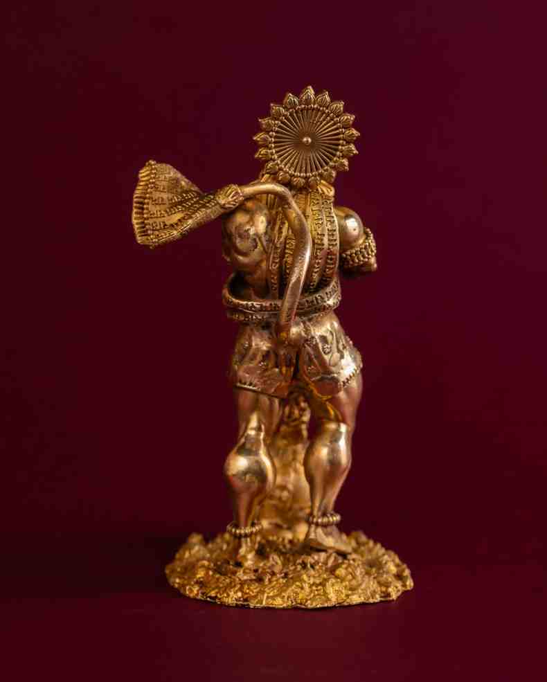 Back-angle view of brass Hanuman idol highlighting sculpted drapery, mace detailing, and textured brass finish.