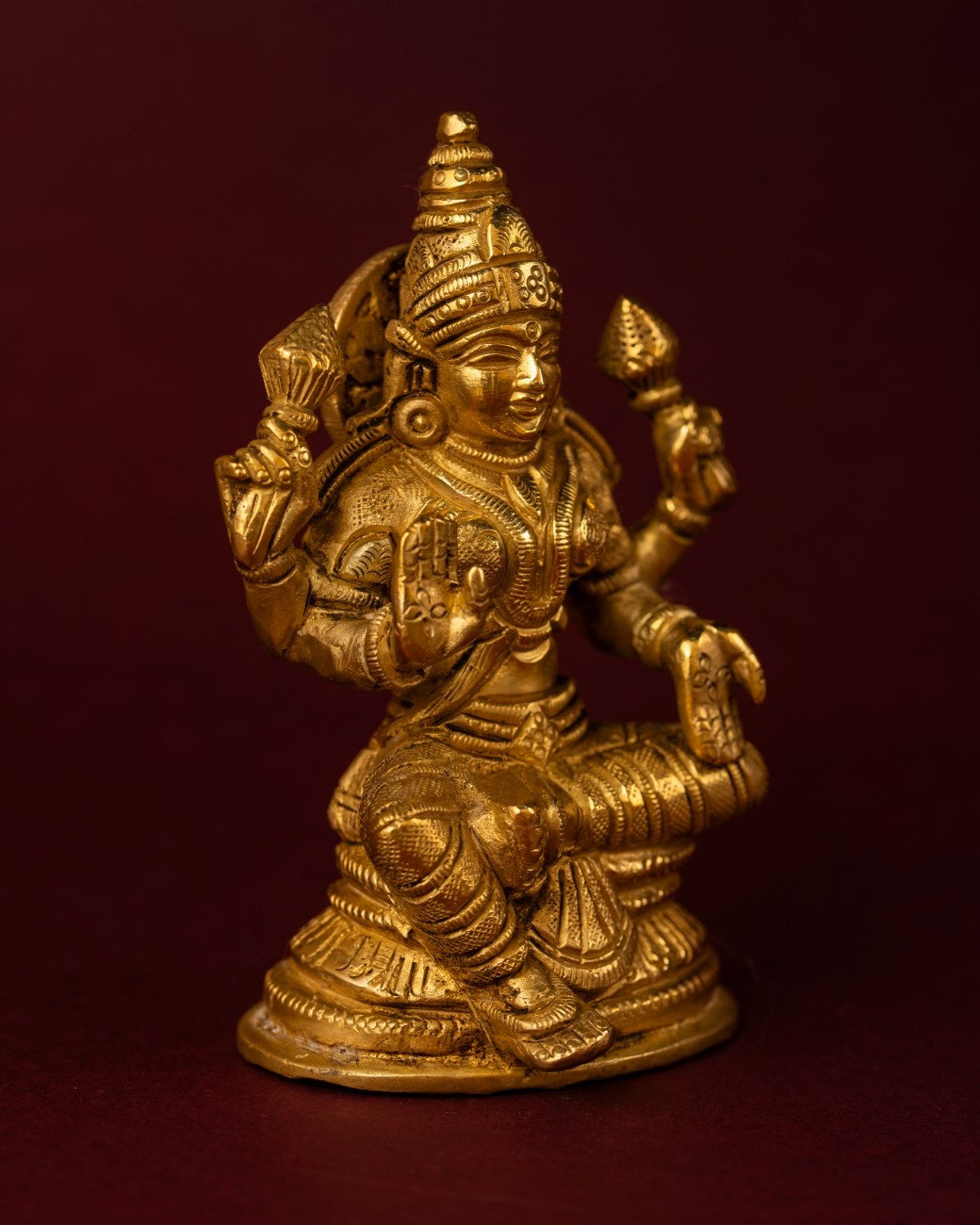 Side view of a seated brass sculpture of Goddess Lakshmi – traditional Indian brass statue for spiritual décor.