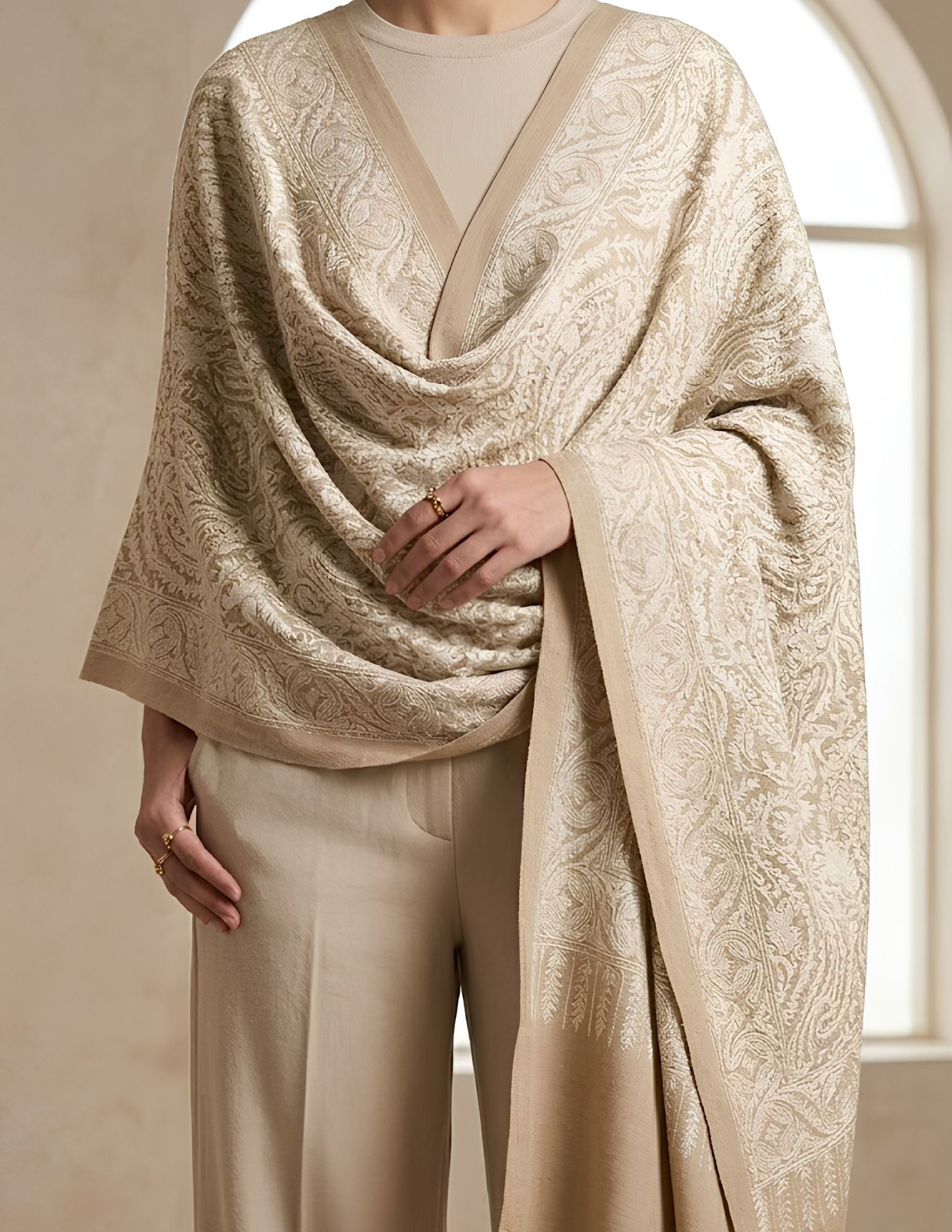 Close-up of tone-on-tone Sozni paisley and floral vine embroidery on ivory wool silk.