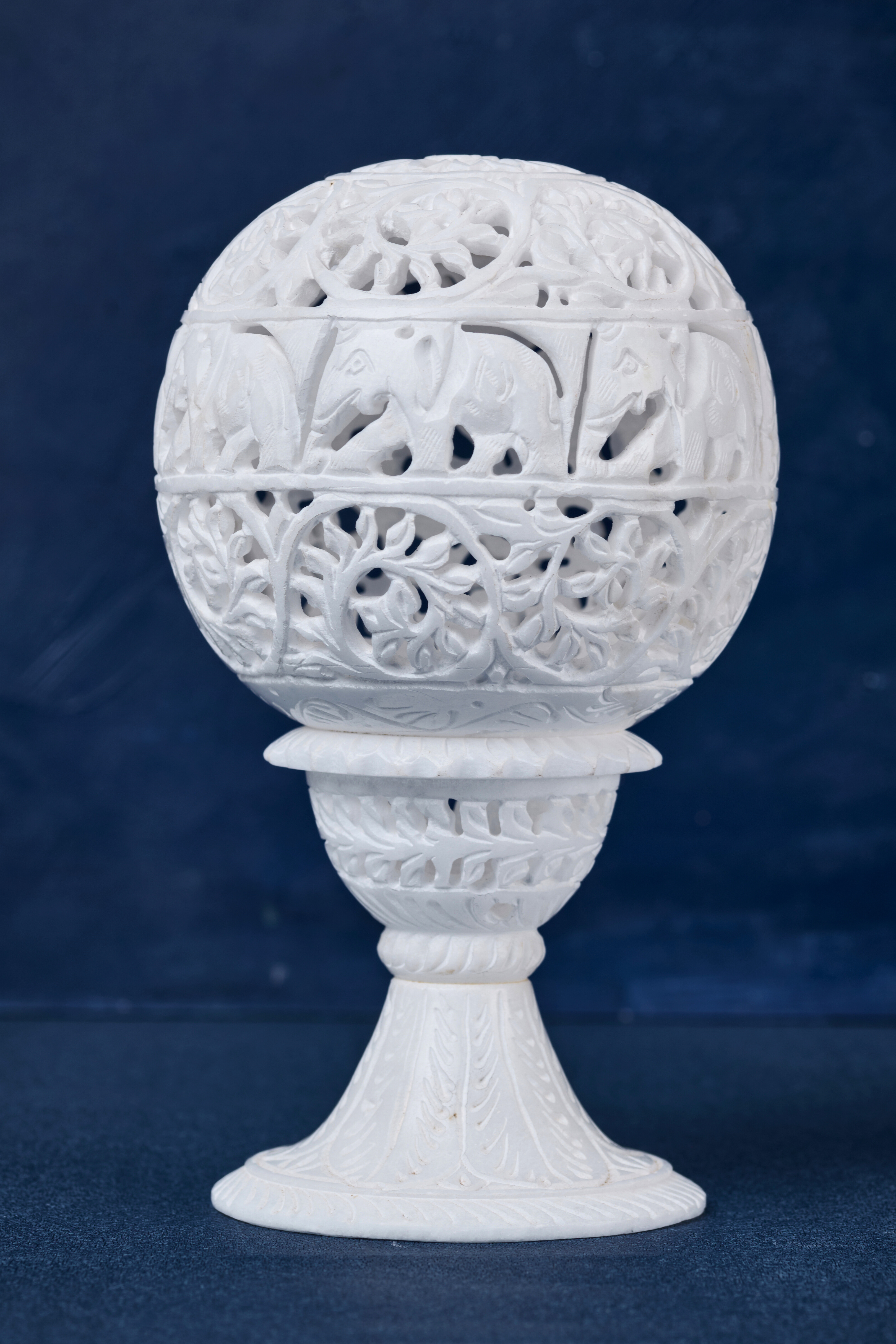 Detailed carving of elephants and vines on soapstone lamp – traditional Indian craftsmanship accent