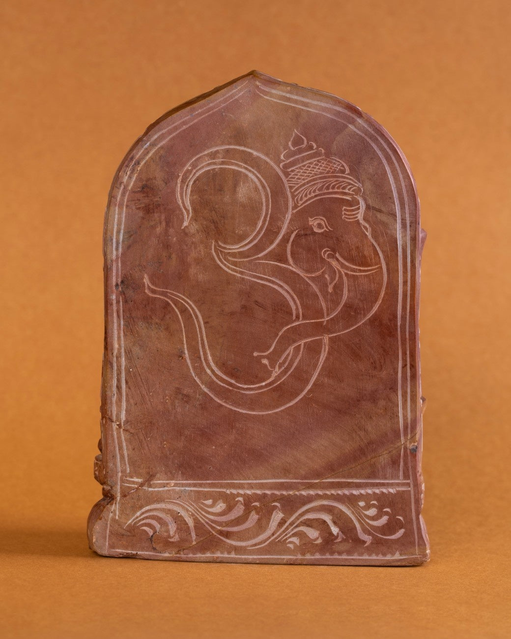 Back view red stone Ganesh statue highlighting stone texture and finish