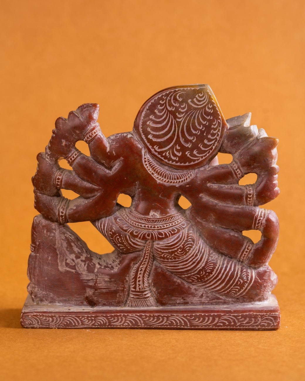 Detail of carving on red stone Kali statue – fine Indian stone sculpture.