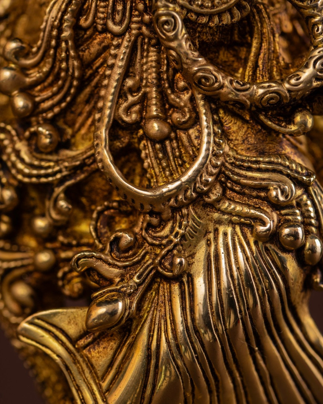 Detailed close-up of Radha statue jewelry and carved brass textures, showcasing Indian artisan craftsmanship.