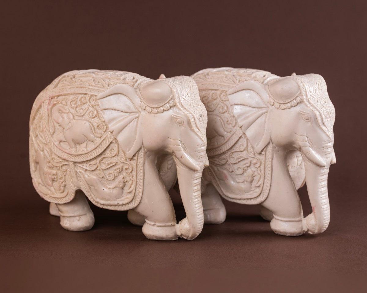 Decorative elephant figurines white carved set with intricate Indian artwork.