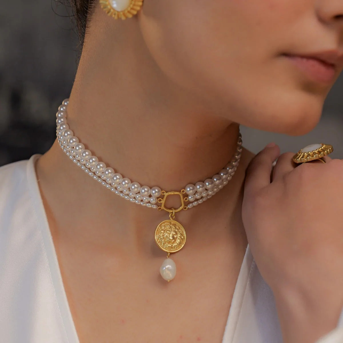 woman wearing gold coin pendant choker with multi-layer pearl strands