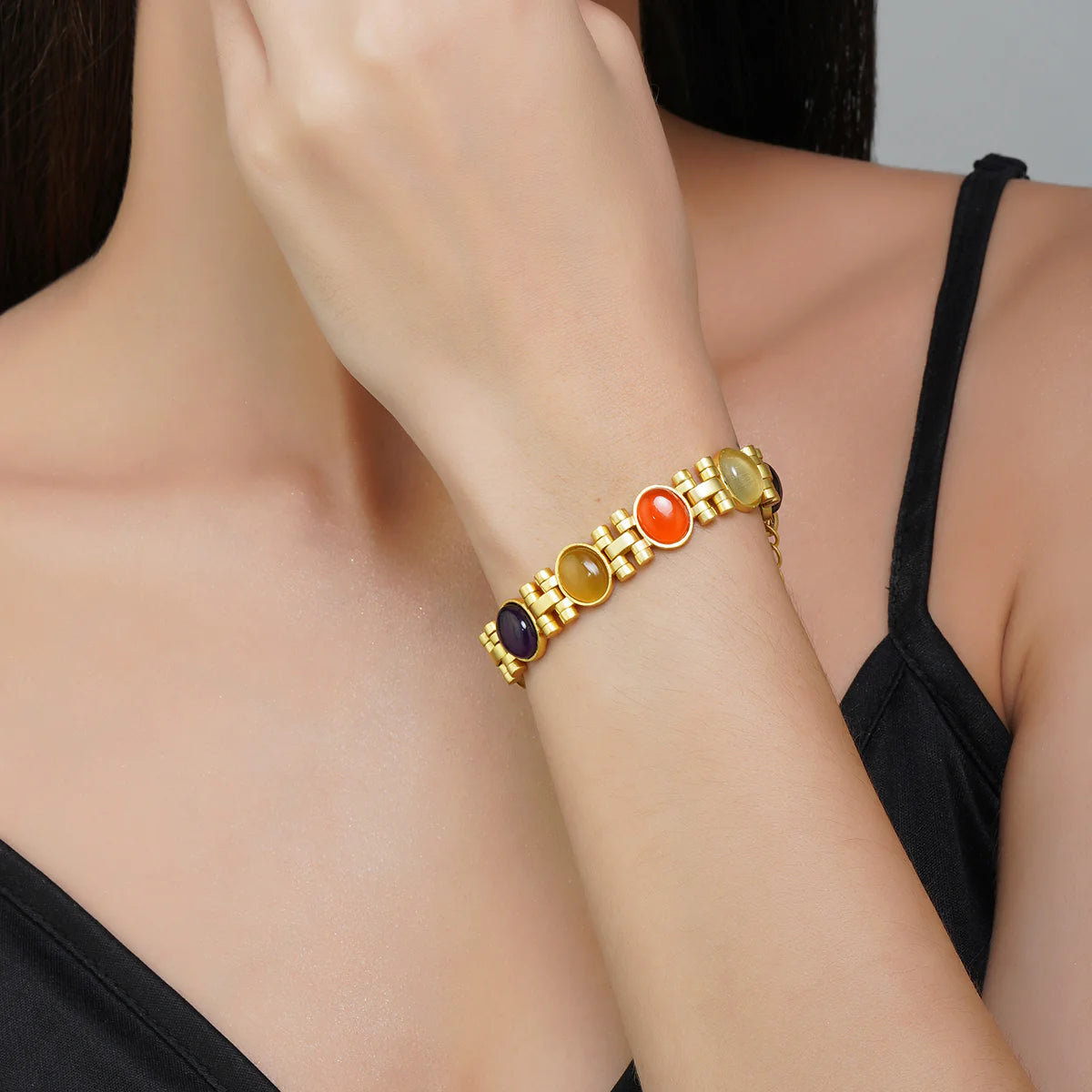 Gold Navratna gemstone bracelet styled on model’s wrist