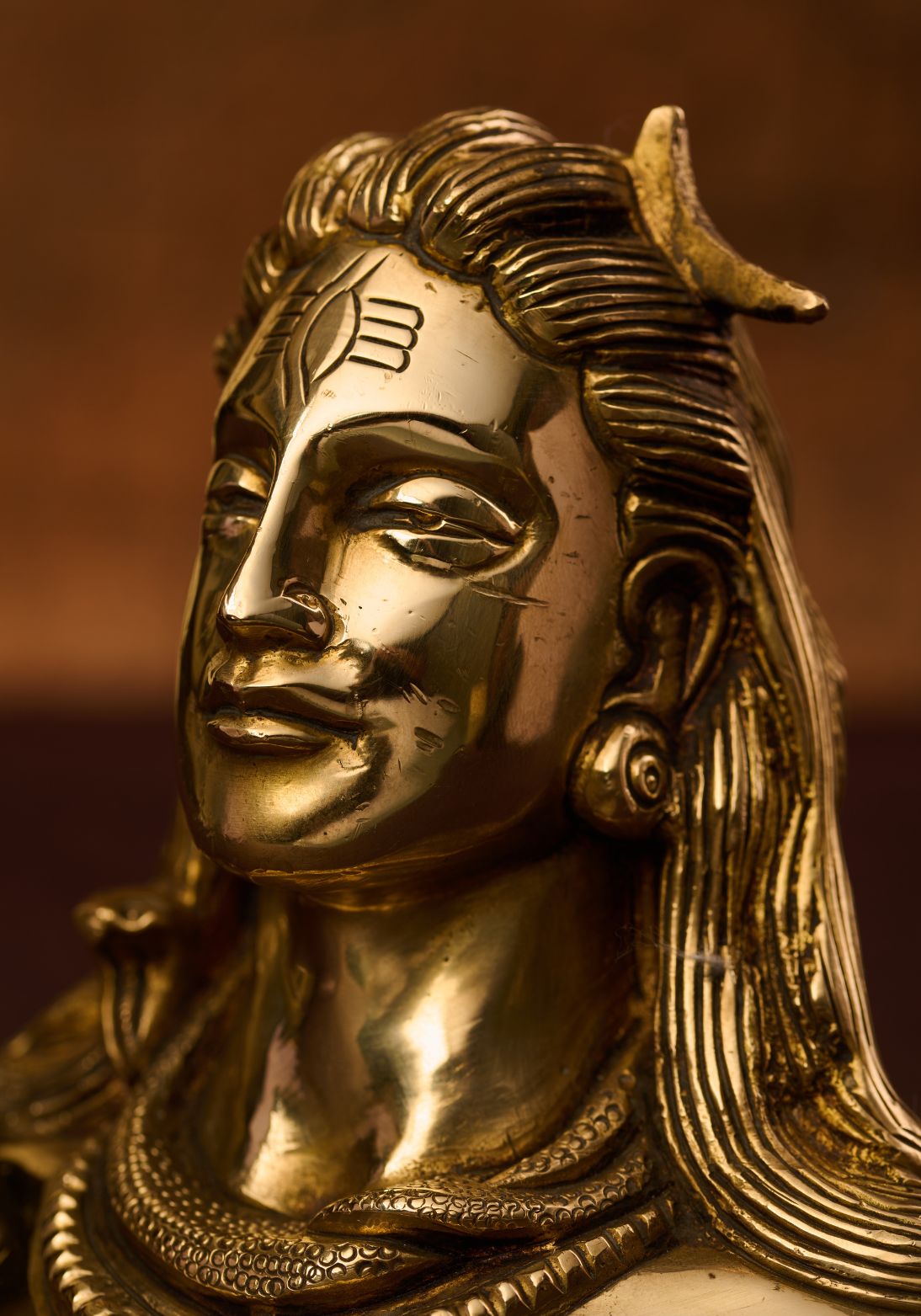 Close‑up of face on brass bust of Adiyogi Shiva – artisan craftsmanship showcasing shivas third eye