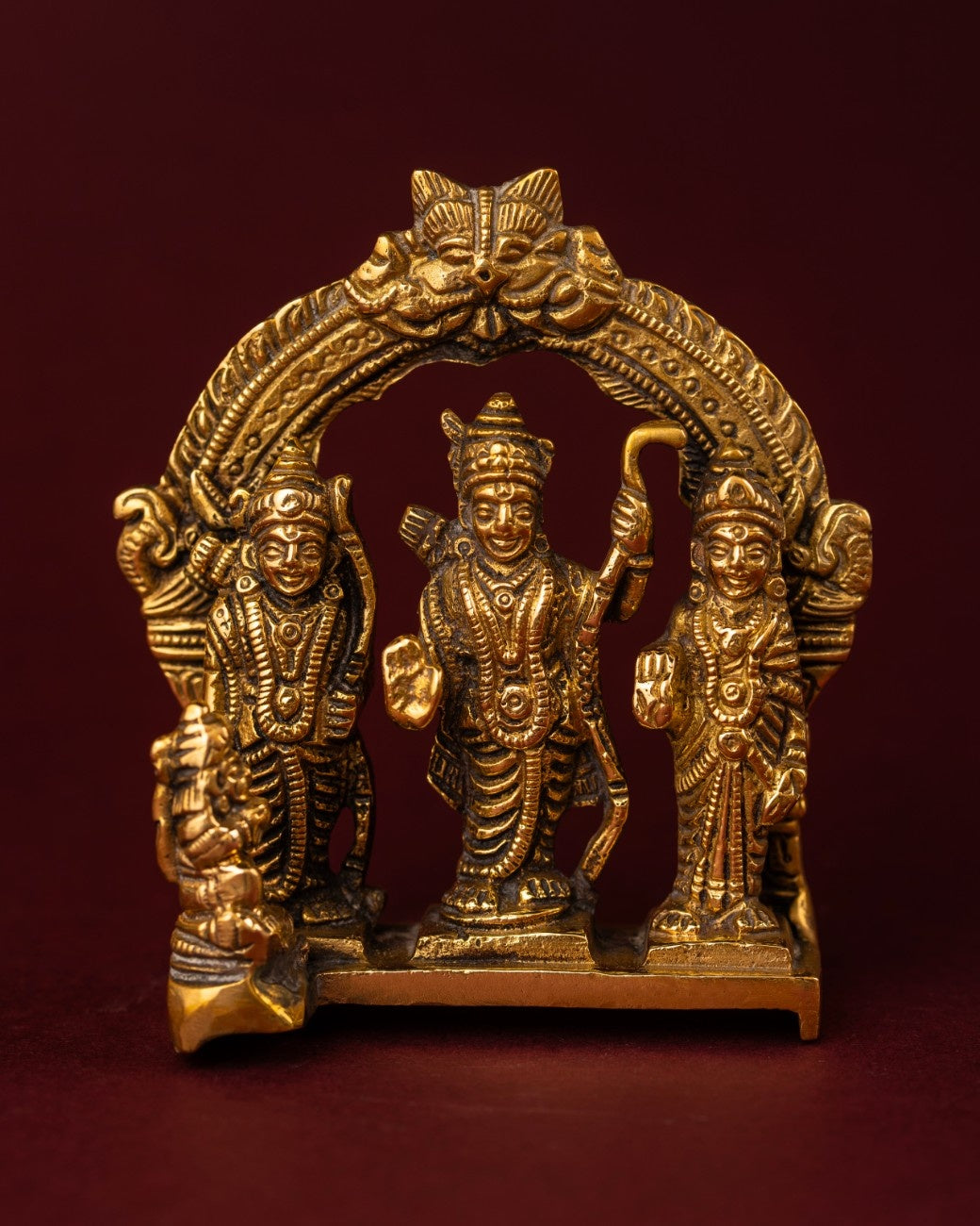 Brass Ram Darbar statue with Rama, Sita, Lakshmana, and Hanuman under carved arch, traditional Hindu devotional décor.