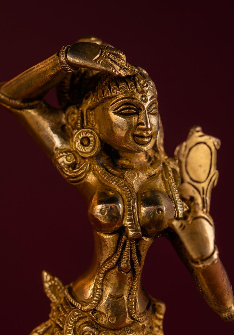Close‑up detail of brass dancing lady holding mirror – fine Indian brass sculpture.