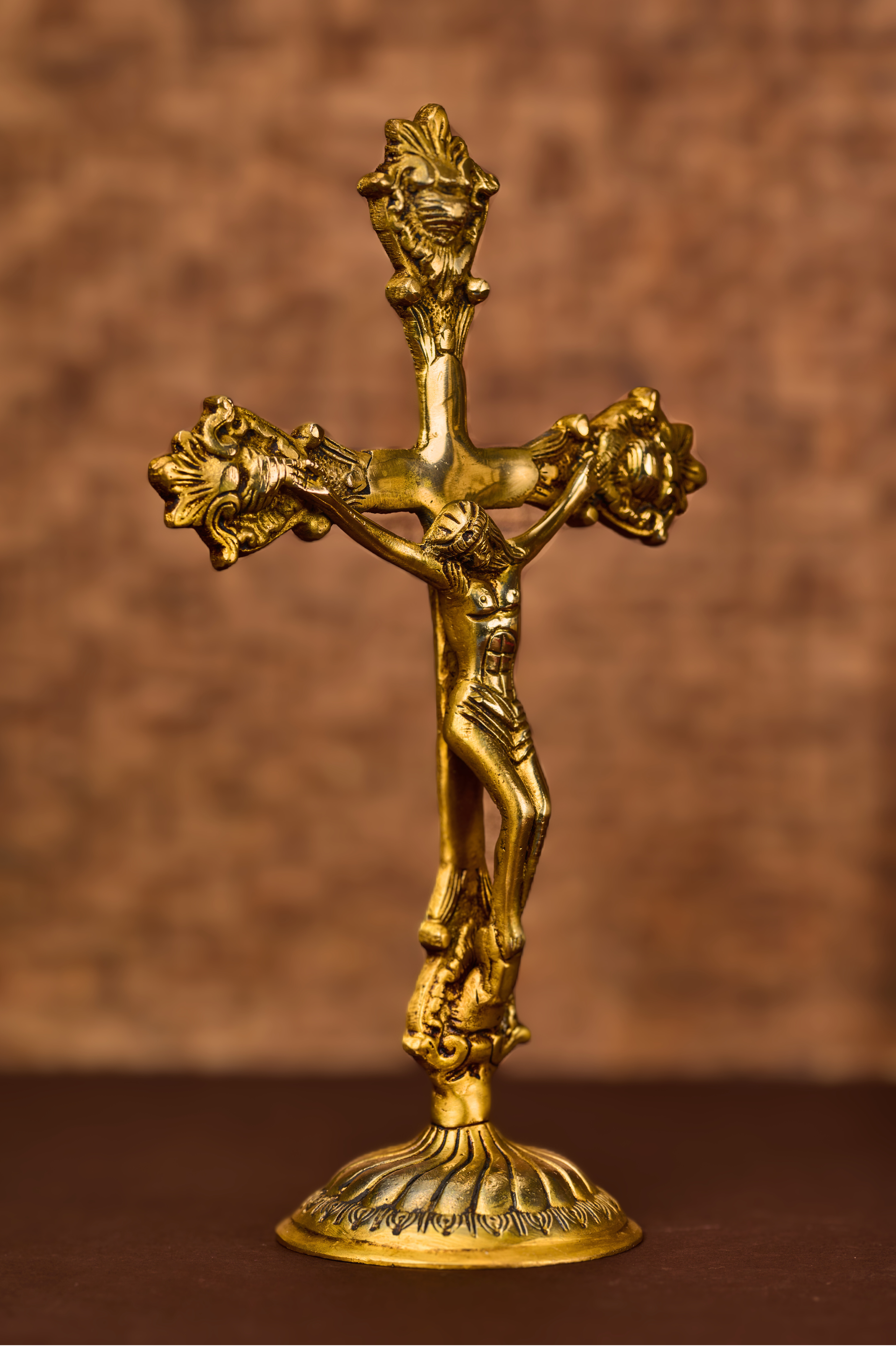 Etched brass Christ on cross with detailed carving and polished finish, standing Christian crucifix statue.