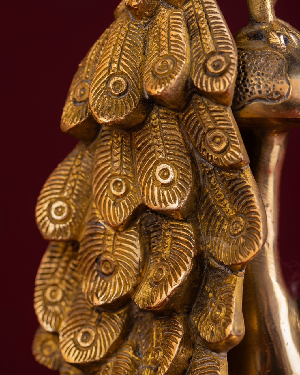 Close-up of brass peacock statue with intricate patterns