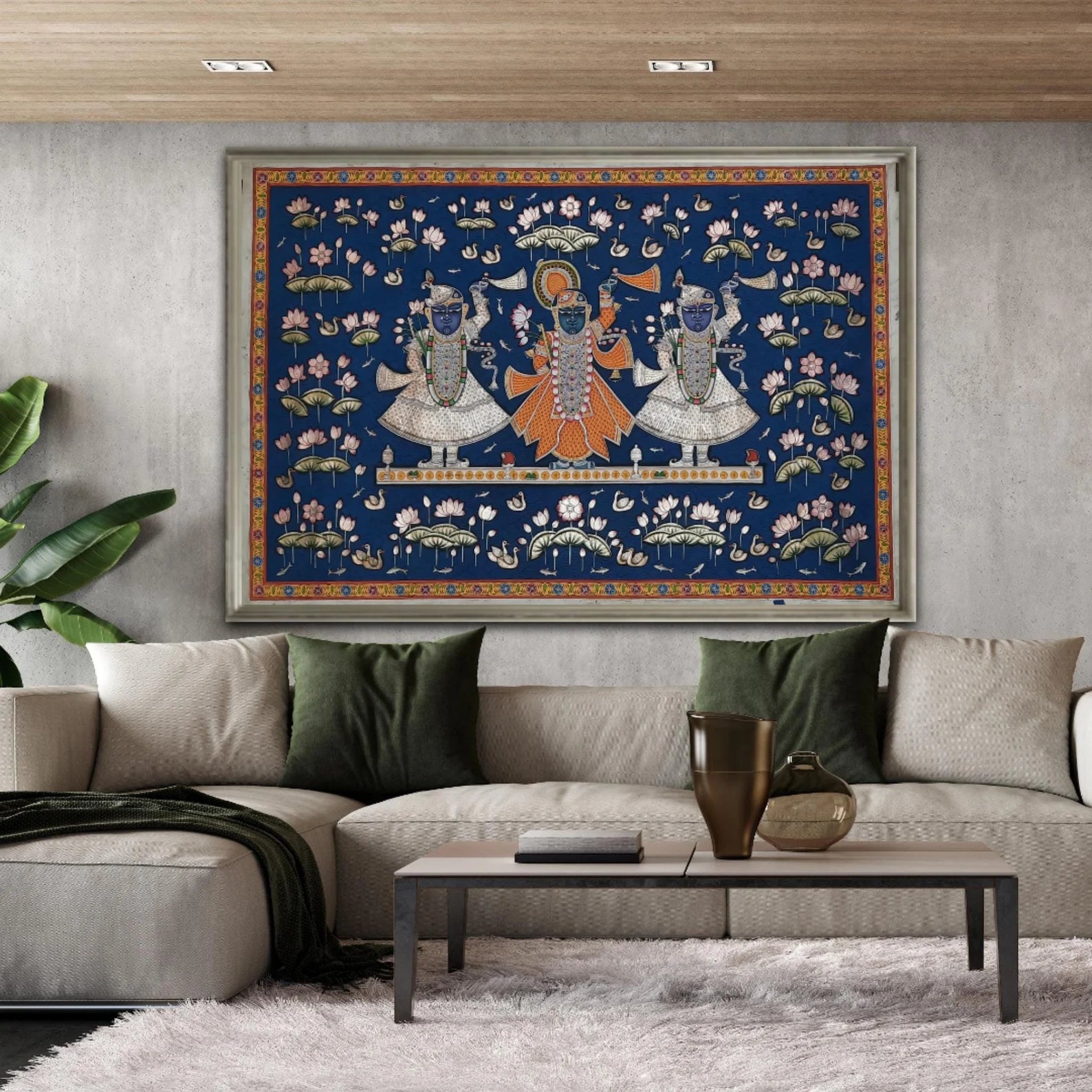 Lord Shrinathji Pichwai painting framed and displayed above a sofa, showing scale and devotional presence in a modern living space