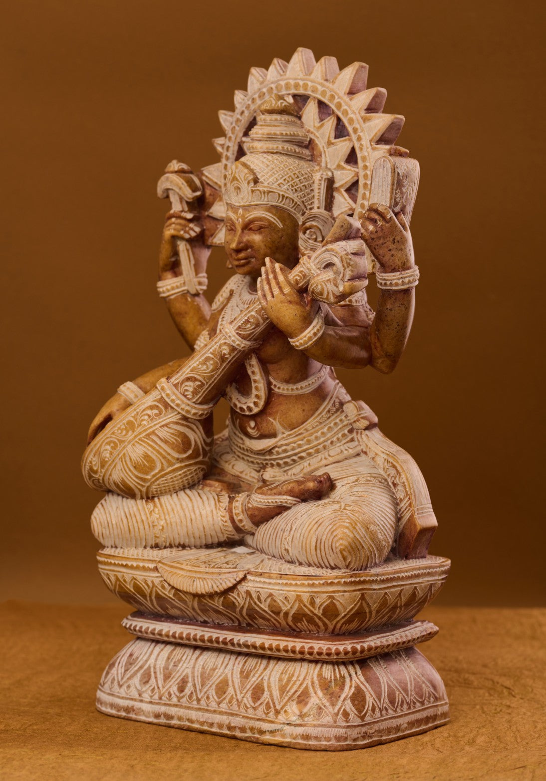Red stone Saraswati sculpture four‑armed depiction of knowledge, arts and music