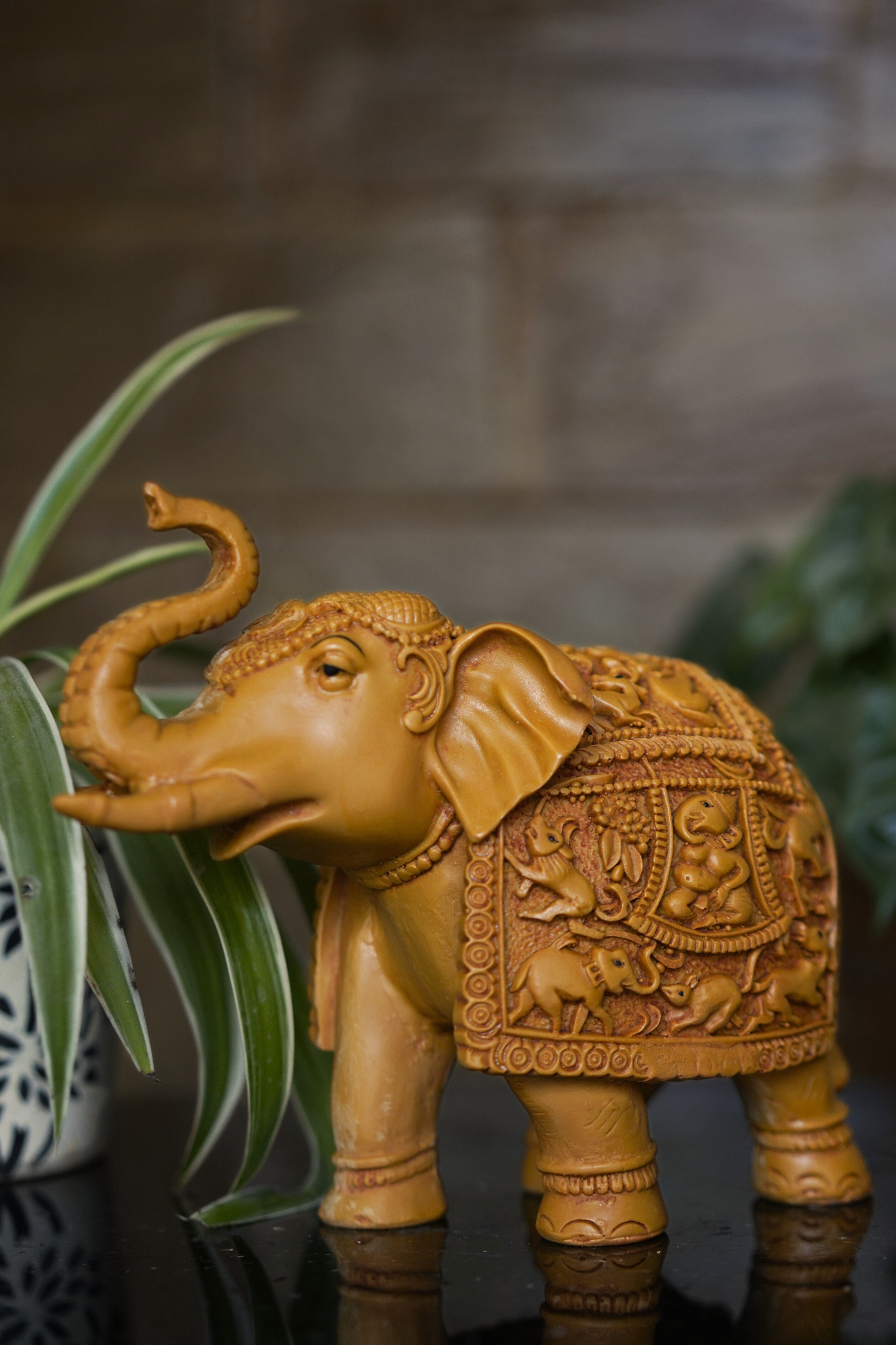 Wooden regal elephant statue crafted with detailed carving, designed as a statement décor accent for living spaces