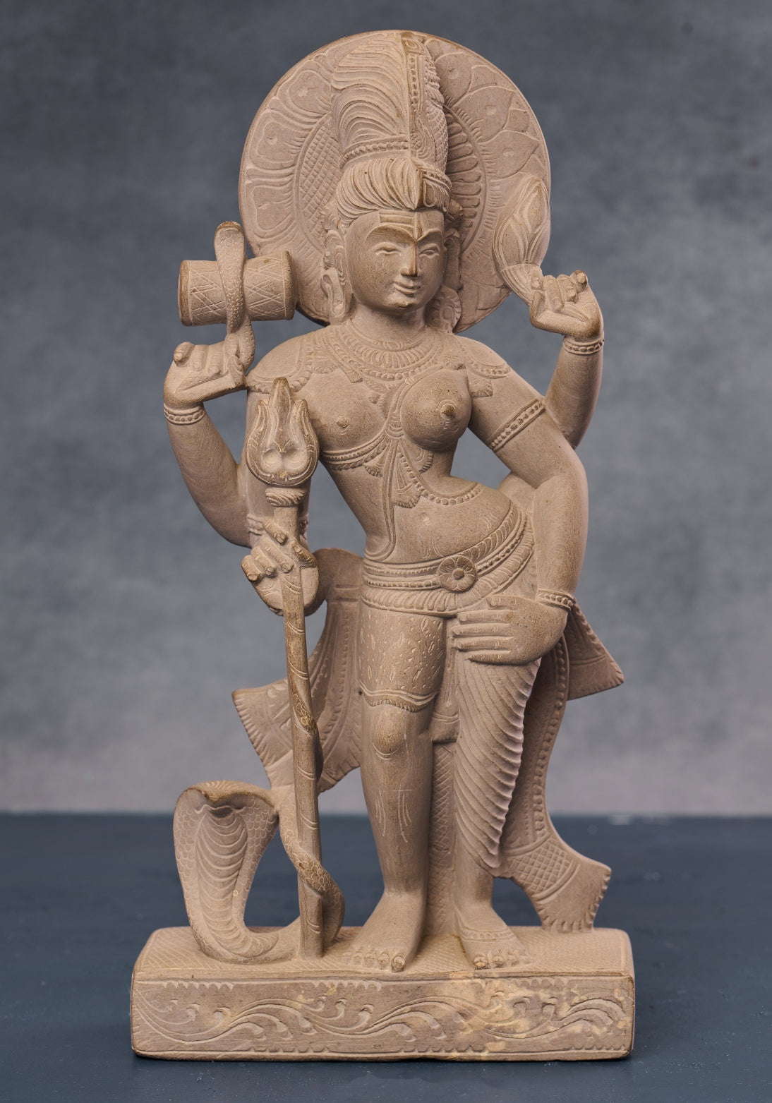 Carved Ardhanarishvara statue depicting half-Shiva half-Parvati form in stone, traditional Hindu deity sculpture for home décor.