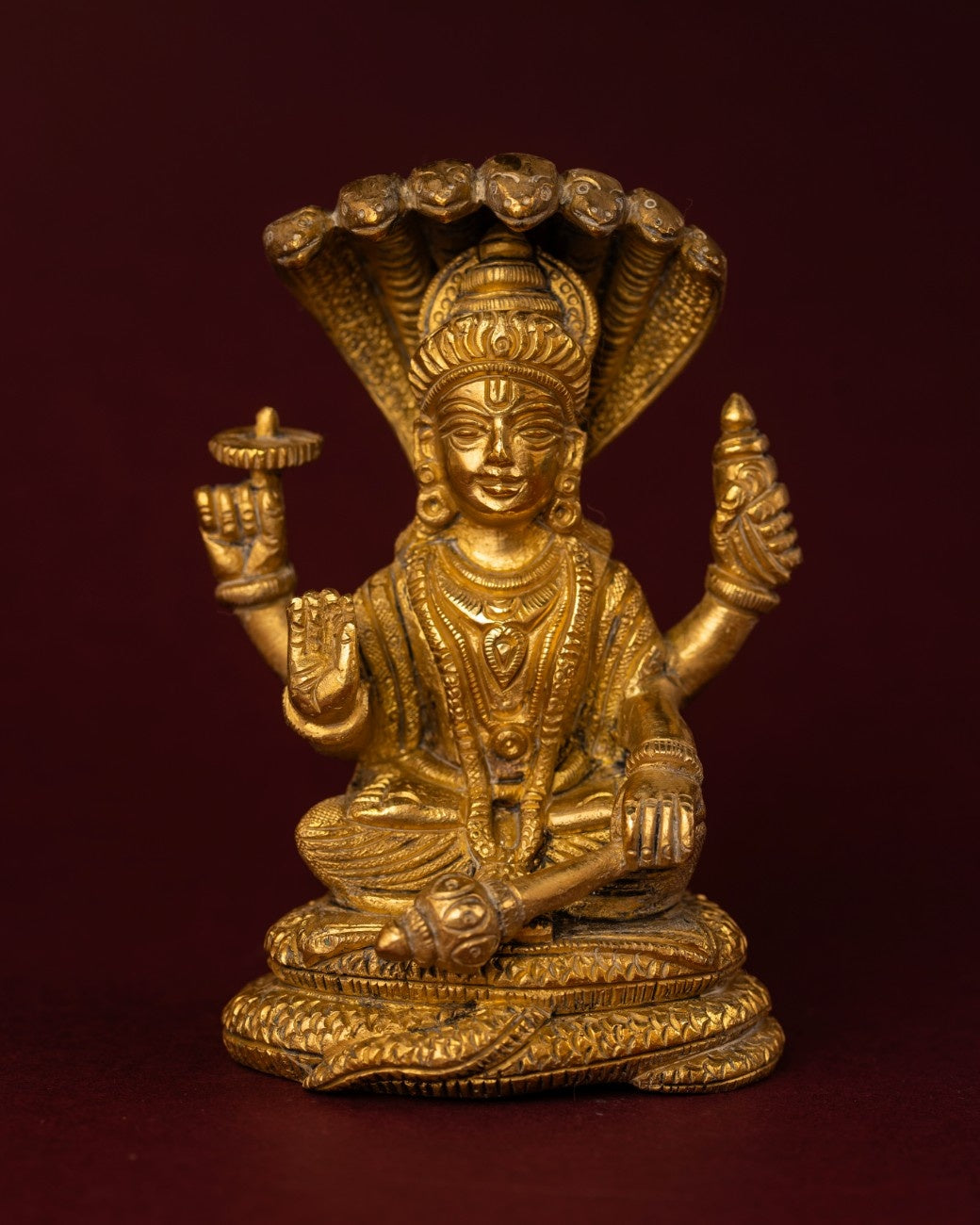 Brass sculpture of Lord Shiva seated in meditation with Naga hood rising behind