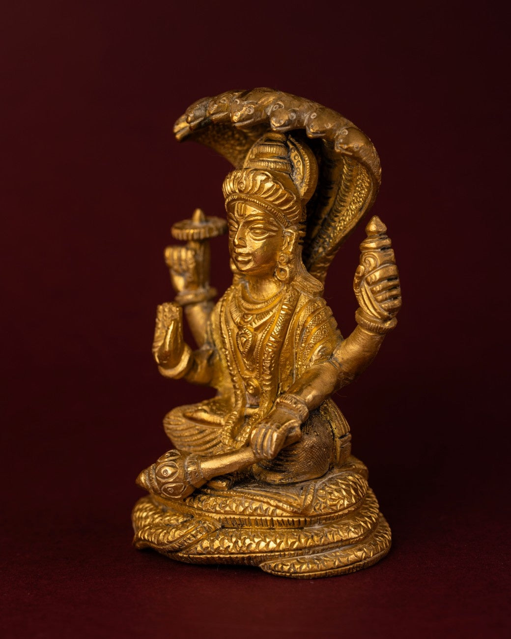 Left angle view of seated Shiva brass statue showing serpent arch and posture