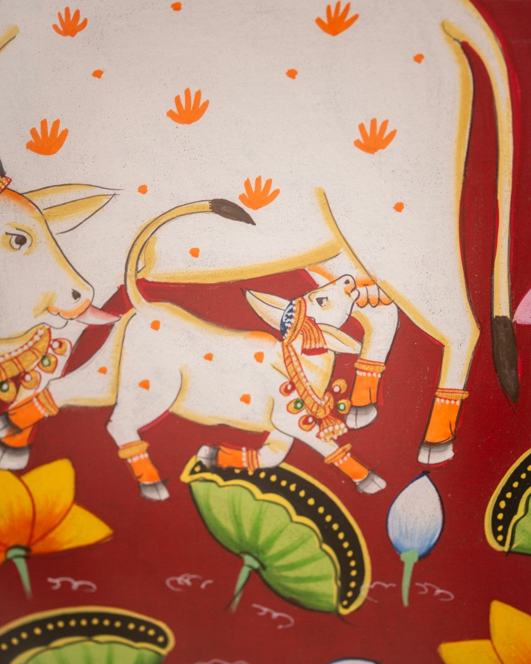Close-up of hand-painted Indian cow artwork with lotus flowers and vibrant detailing