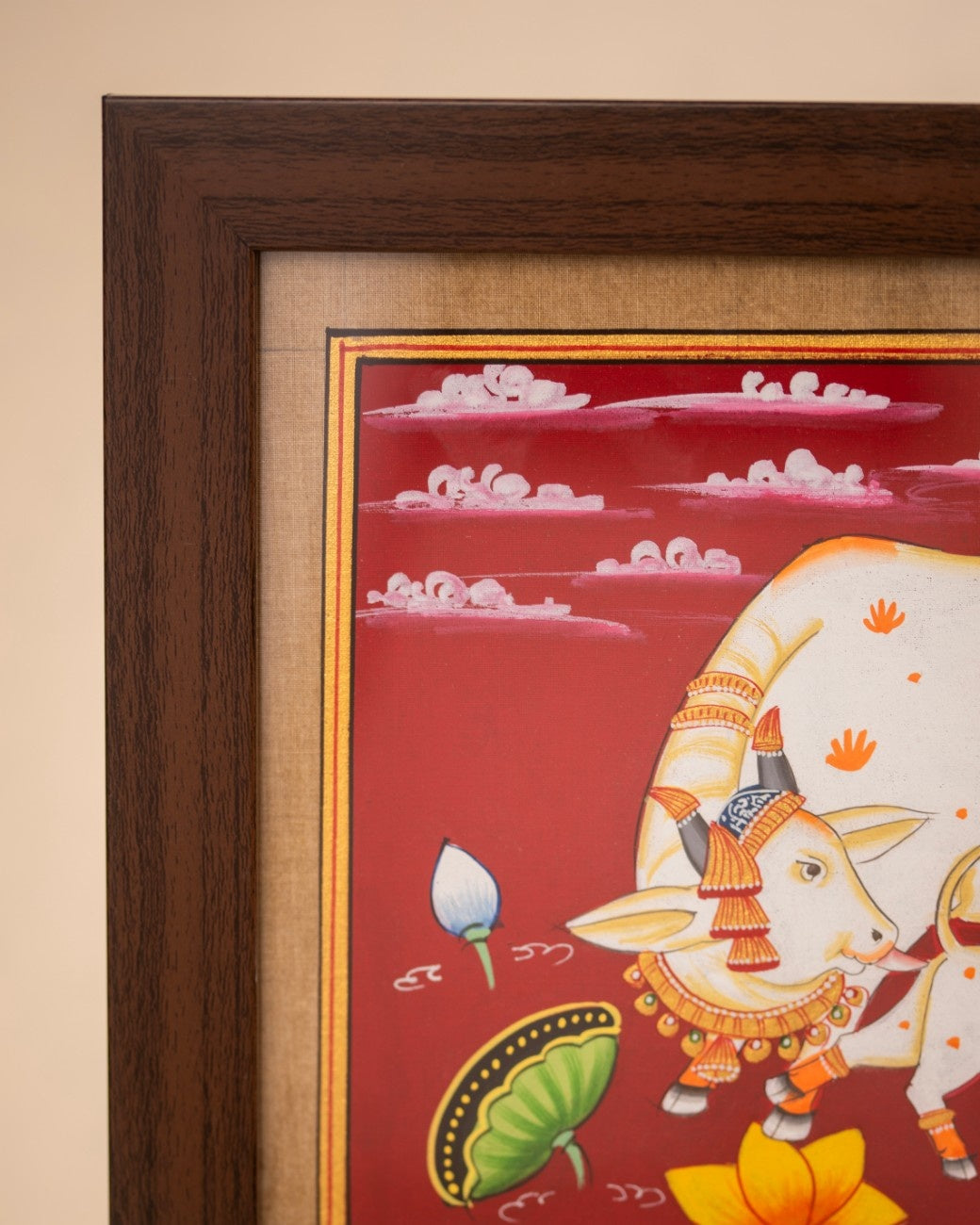 Detail view of traditional Indian cow painting showing colors, brushwork, and wooden frame